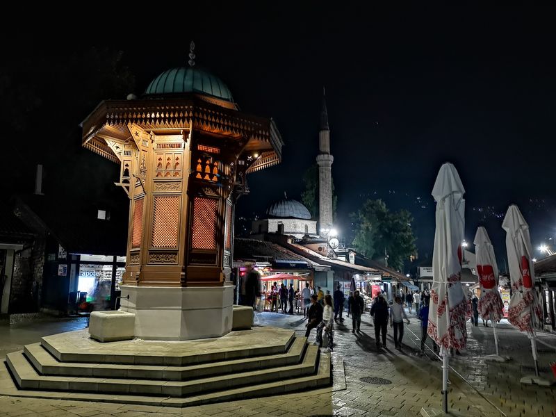 a latticework fountain about 3 meters tall, erected in a small, medieval square in Sarajevo