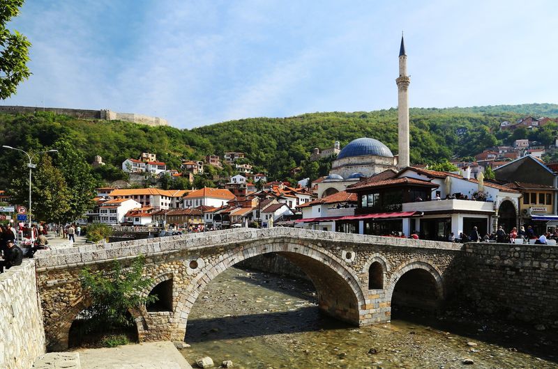 A stone bridge over the low-tide river in Prizren.